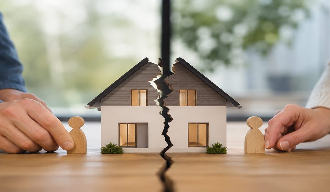 Geteiltes Hausmodell mit zwei Holzfiguren symbolisiert die Aufteilung einer Immobilie bei Trennung ohne Trauschein. I Trennung ohne Trauschein